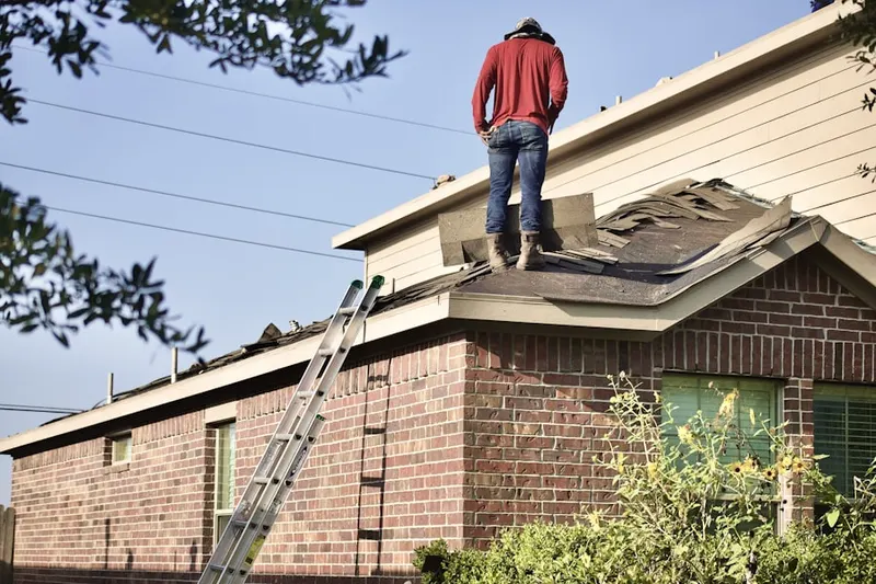 Professional roofer working on a residential roof in Lyons